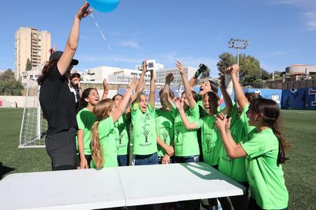 קבוצת בנות מניפות את הגביע